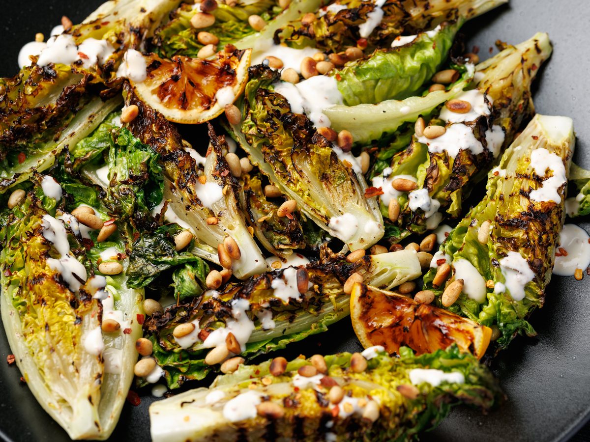 Gegrilde romaine met pijnboompitten, citroen en een romige dressing
